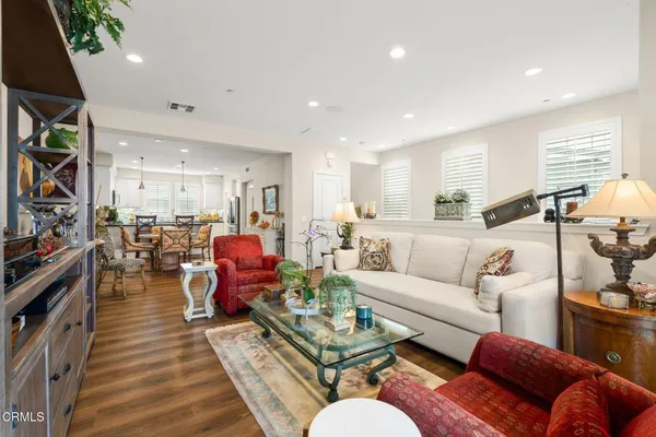 a living room with furniture kitchen view and a window