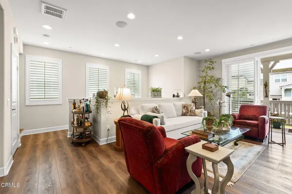 a living room with furniture a wooden floor and a large window