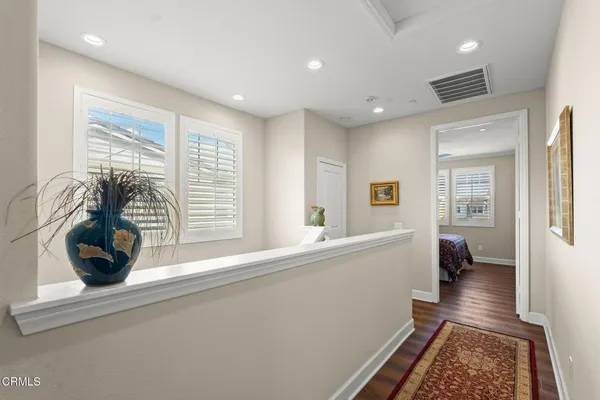 a bedroom with a bed a dresser and wooden floor