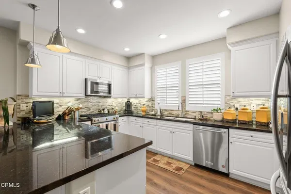 a kitchen with lots of counter top space a sink and appliances