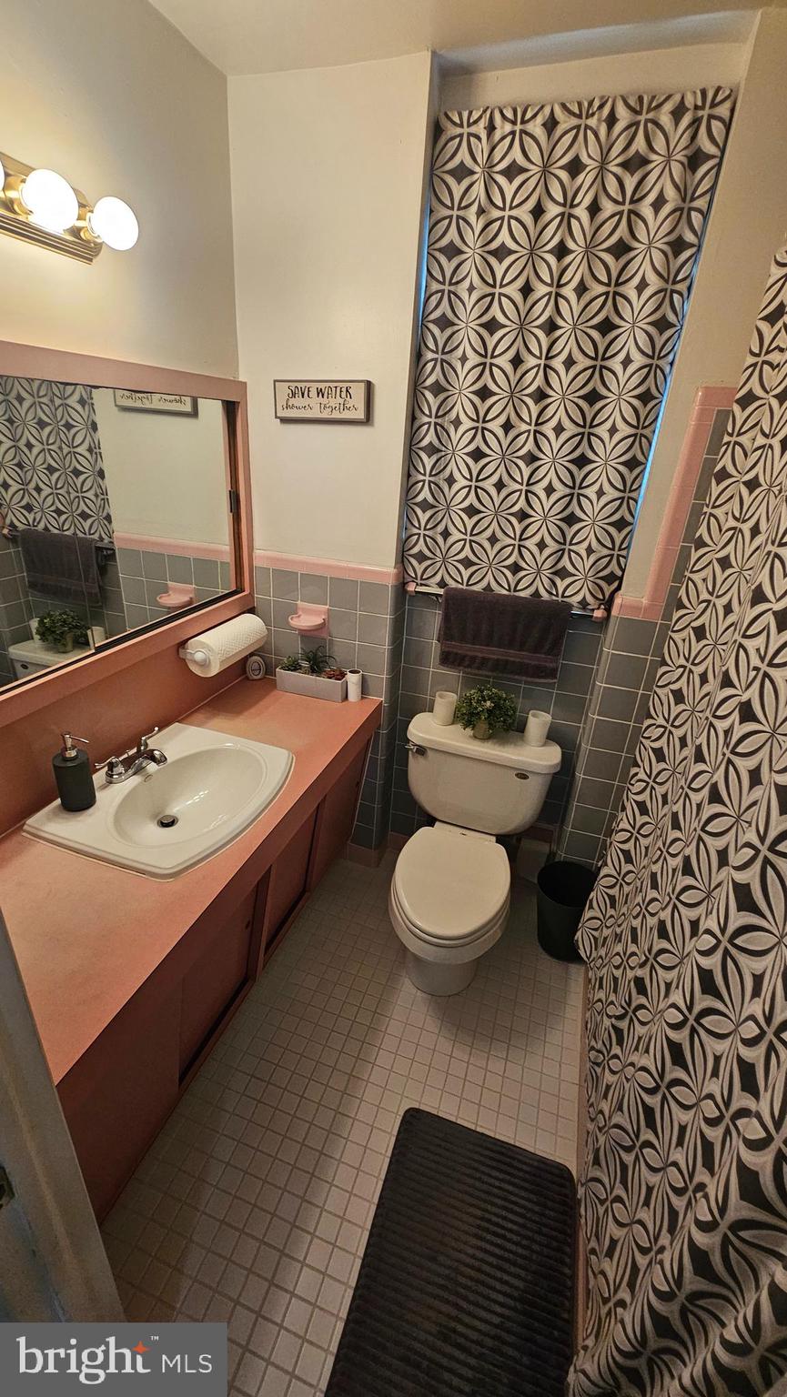 7829 Horrocks Street Philadelphia, PA 19152 - Photo 27 of 46 a bathroom with a sink a toilet and a shower curtain