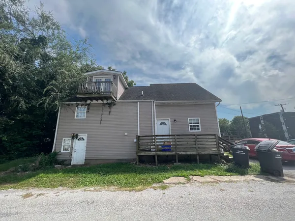 a front view of a house with a garden and parking space
