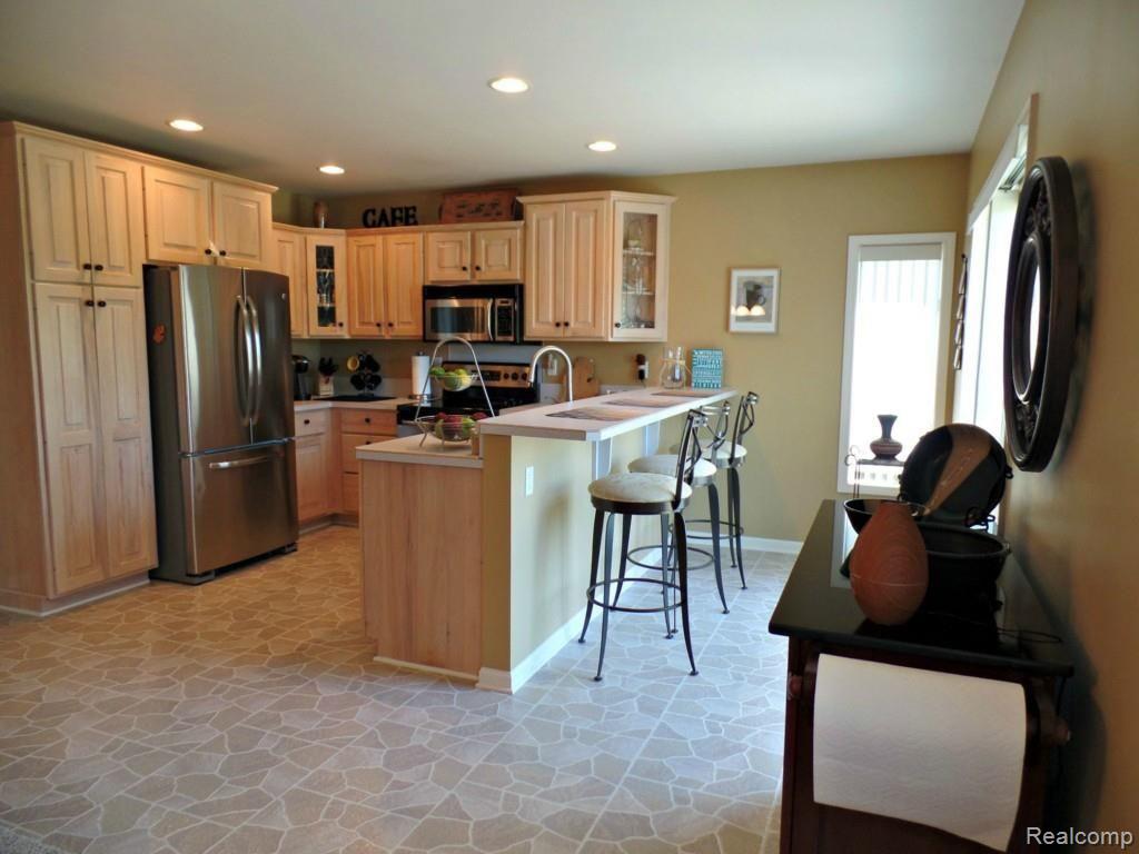 6340 Vassar Road Grand Blanc, MI 48439 - Photo 14 of 51 A well appointed kitchen (appliances stay) offers ample cabinetry, counter space, and breakfast bar seating area.