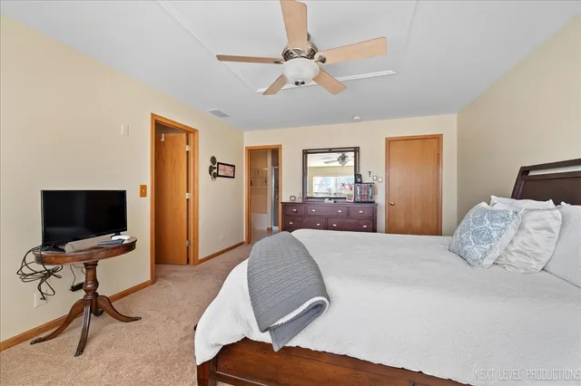a bedroom with a large bed and a chandelier