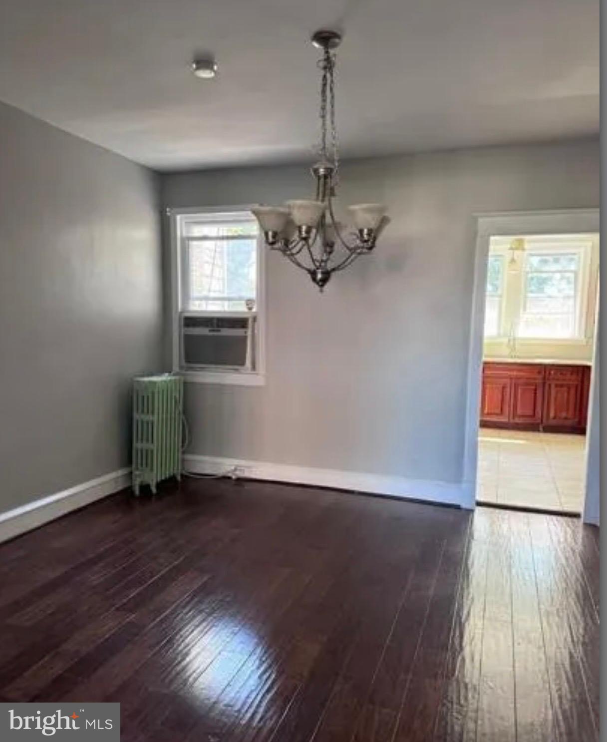 7725 Walker Street Philadelphia, PA 19136 - Photo 4 of 8 an empty room with wooden floor chandelier and windows