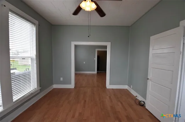 a view of hallway with a large window and wooden floor