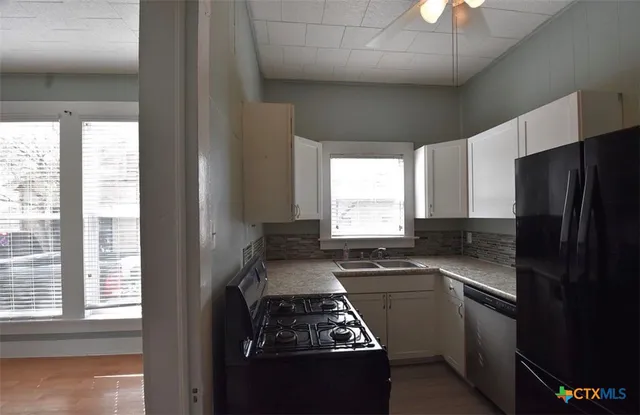 a kitchen with a stove a refrigerator and a window