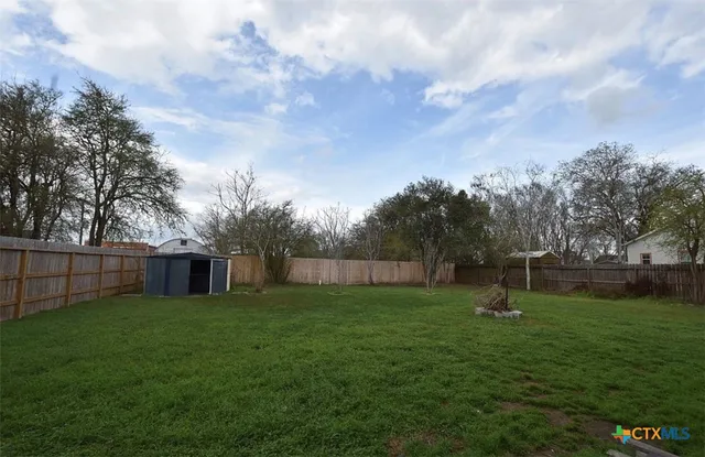 a view of a backyard with a garden and trees