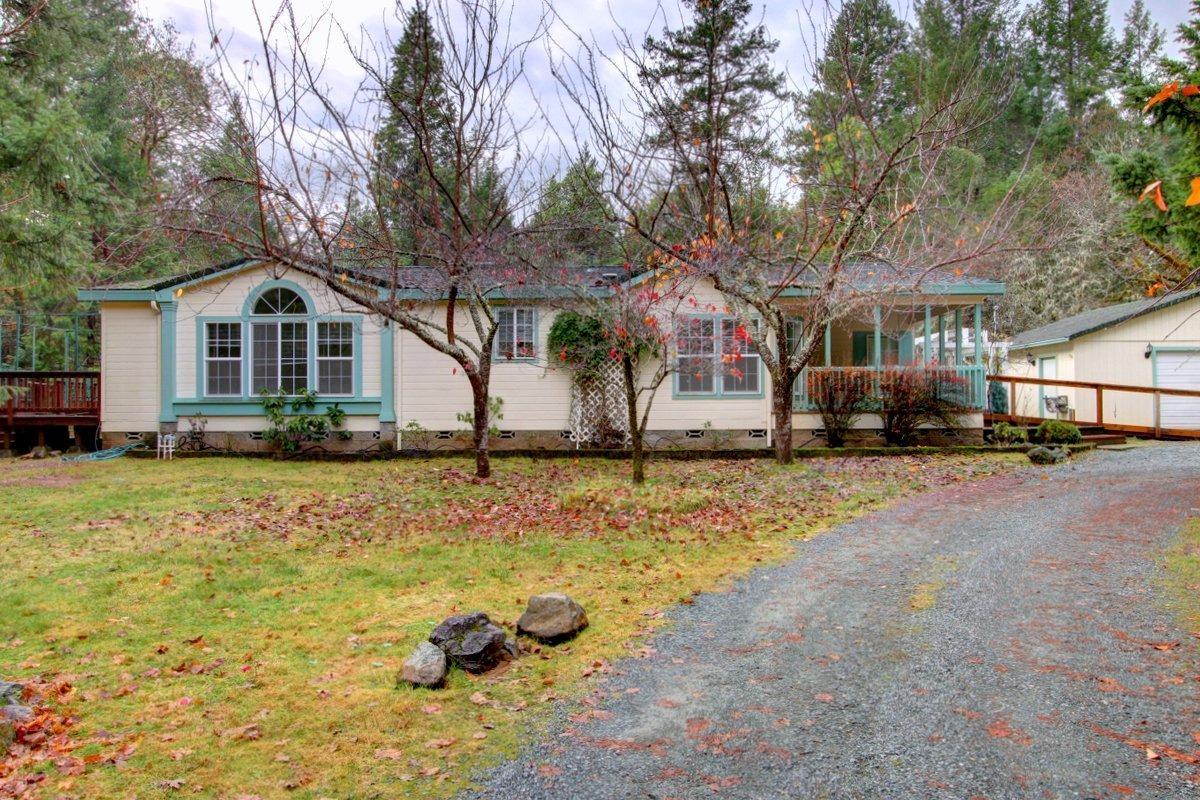 2101 Queens Branch Road Rogue River, OR 97537 - Photo 1 of 25 a front view of a house with a yard covered with trees