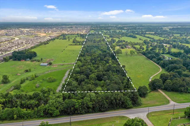 an aerial view of residential houses with outdoor space and trees