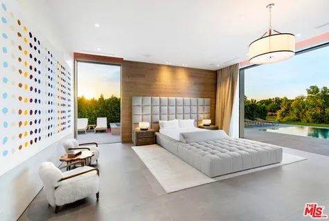 a bedroom with furniture and a large window