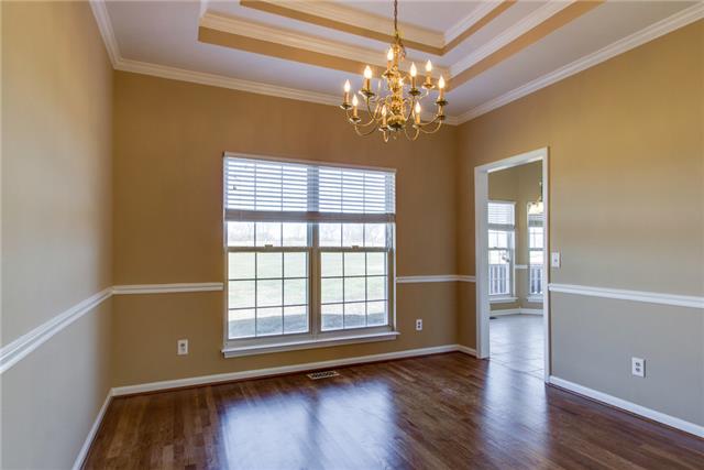 306 Eastside Road Burns, TN 37029 - Photo 8 of 19 The formal dining space features a double tray ceiling, crown molding, lots of natural light, and newly refinished hardwood floors.