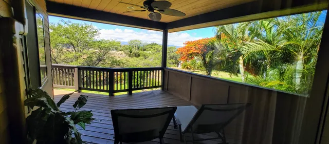 a view of an empty room with wooden floor and doors