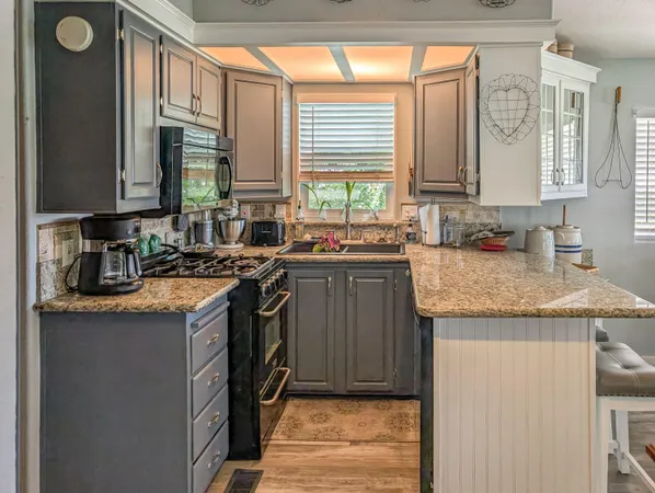 a kitchen with stainless steel appliances granite countertop a sink stove and cabinets