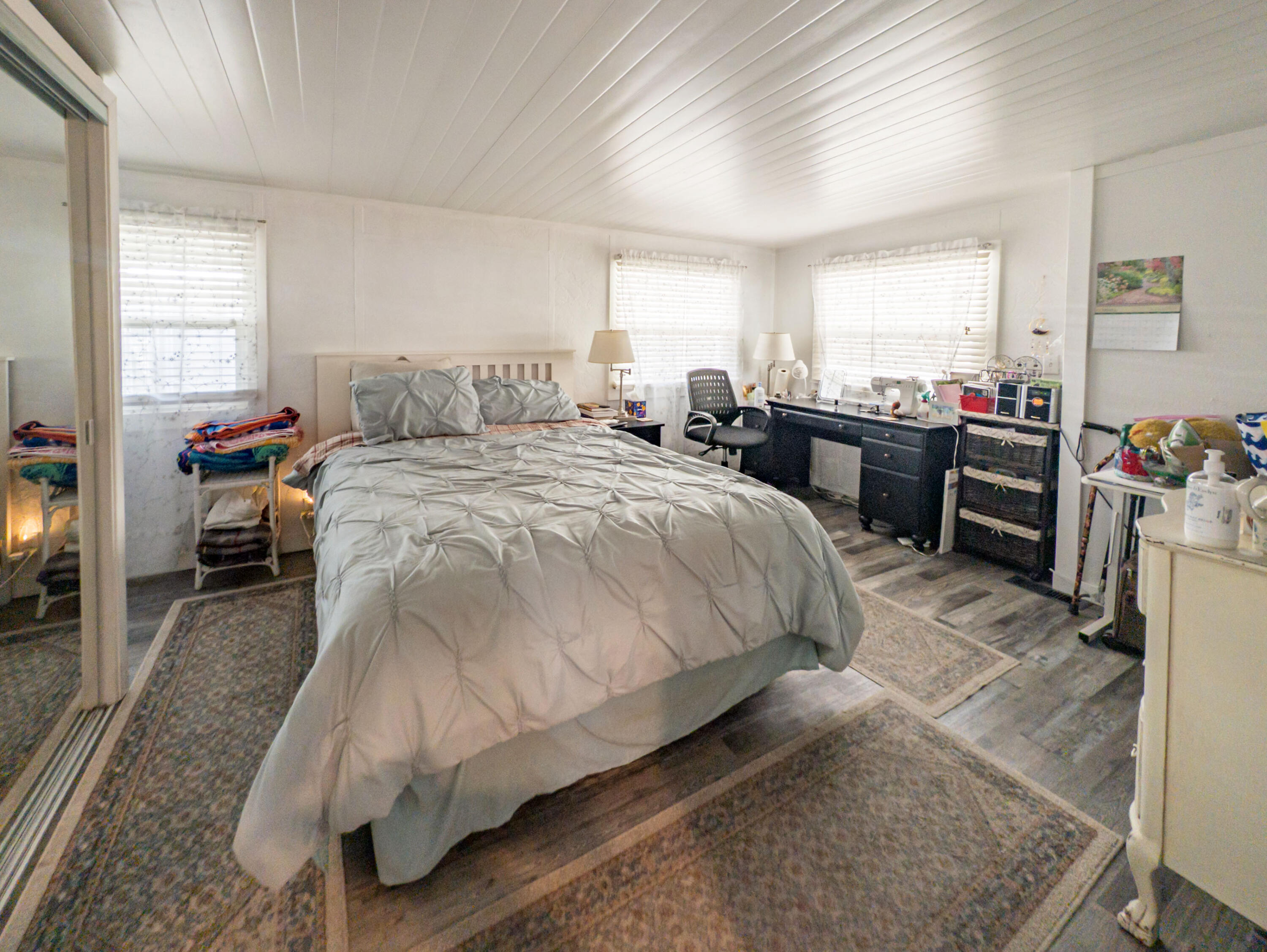 70200 Dillon Road, Unit 665 Desert Hot Springs, CA 92241 - Photo 24 of 40 a spacious bedroom with a bed a couch and dresser
