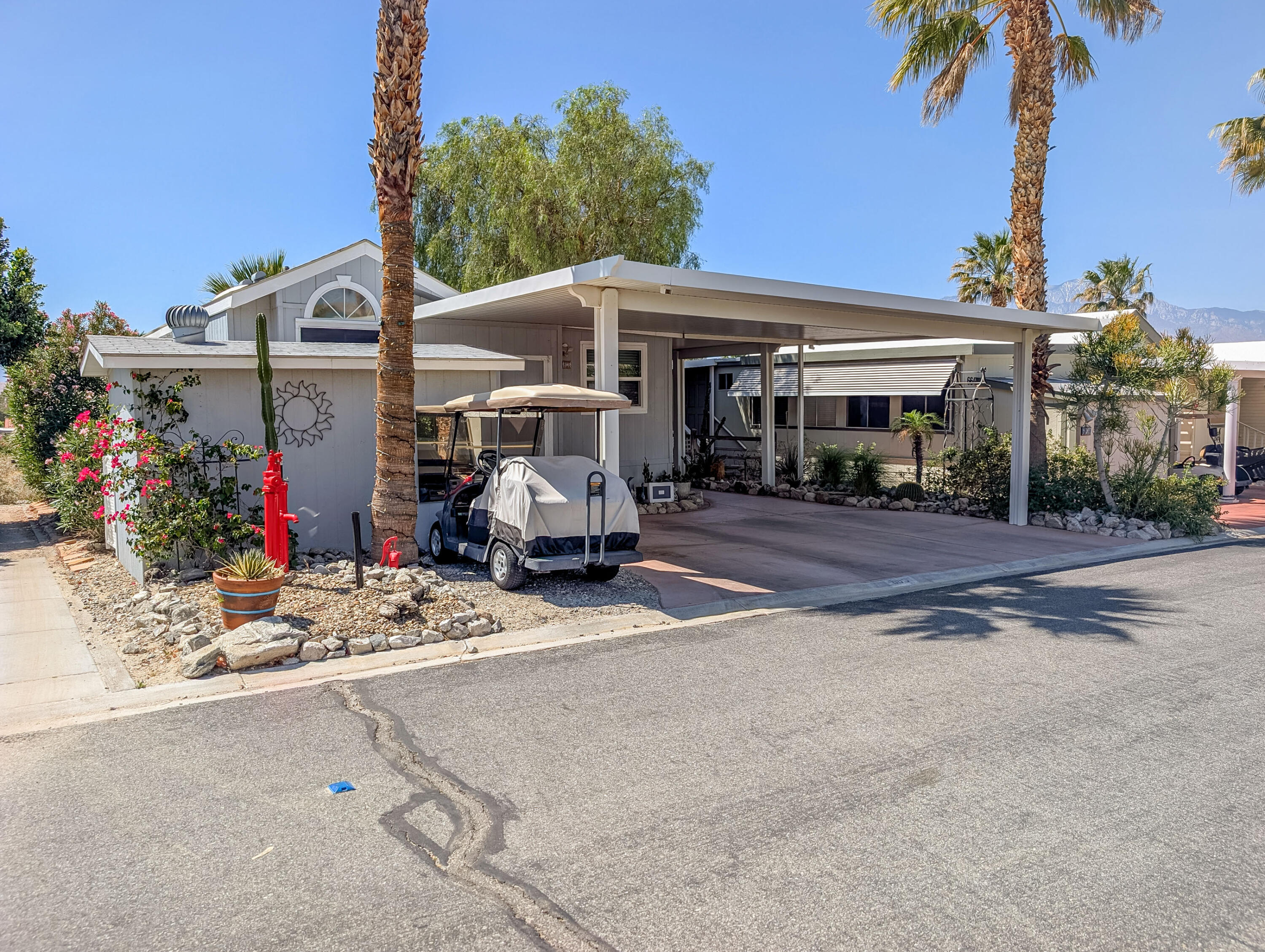 70200 Dillon Road, Unit 665 Desert Hot Springs, CA 92241 - Photo 3 of 40 a front view of a house with garden