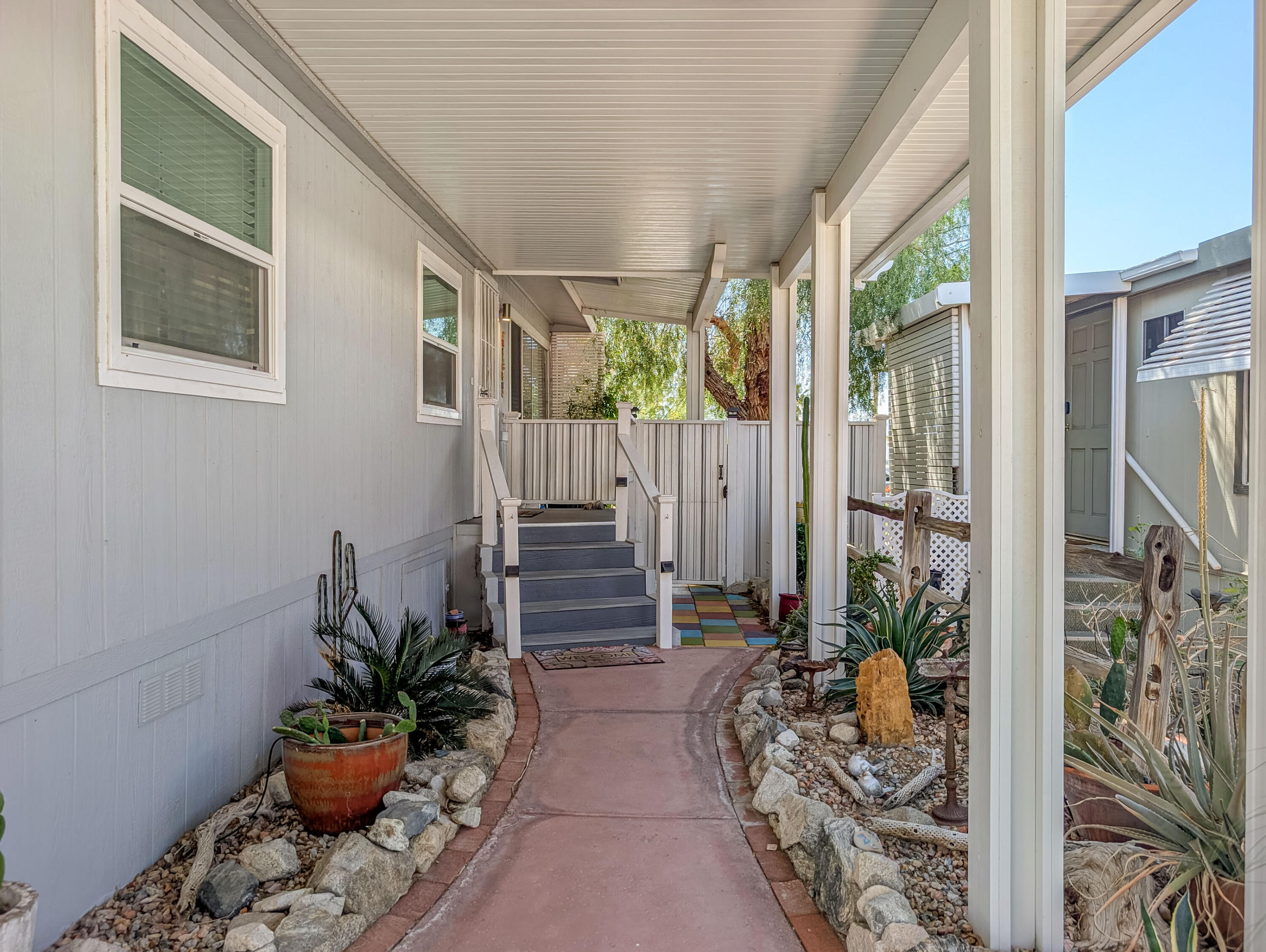 70200 Dillon Road, Unit 665 Desert Hot Springs, CA 92241 - Photo 7 of 40 a porch with chairs and potted plants