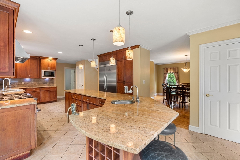 122 Depot Road Boxford, MA 01921 - Photo 4 of 41 a dining hall with stainless steel appliances kitchen island granite countertop a dining table and chairs with wooden floor