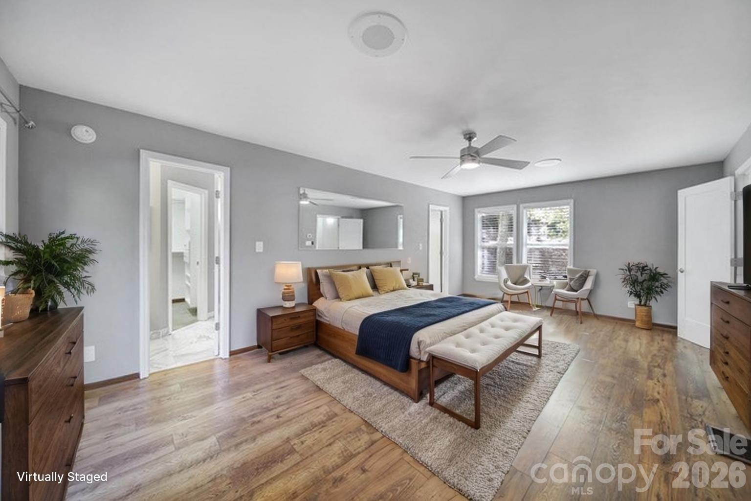 7005 Tega Cay Drive Tega Cay, SC 29708 - Photo 16 of 48 a spacious bedroom with a bed a couch and a potted plant with wooden floor