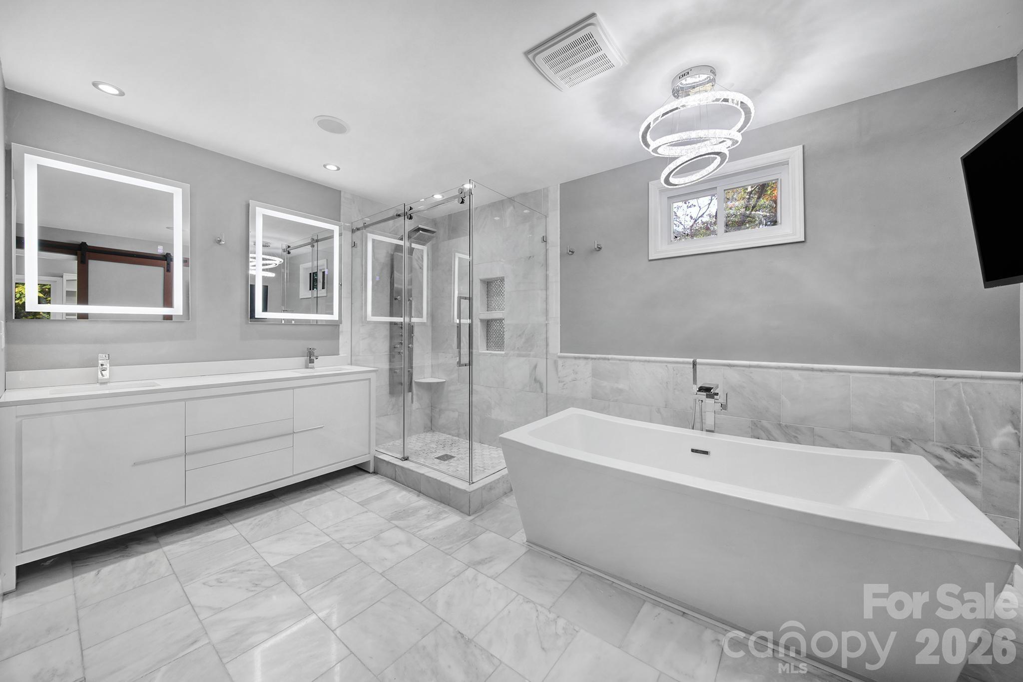 7005 Tega Cay Drive Tega Cay, SC 29708 - Photo 24 of 48 a spacious bathroom with a bathtub a mirror and a sink