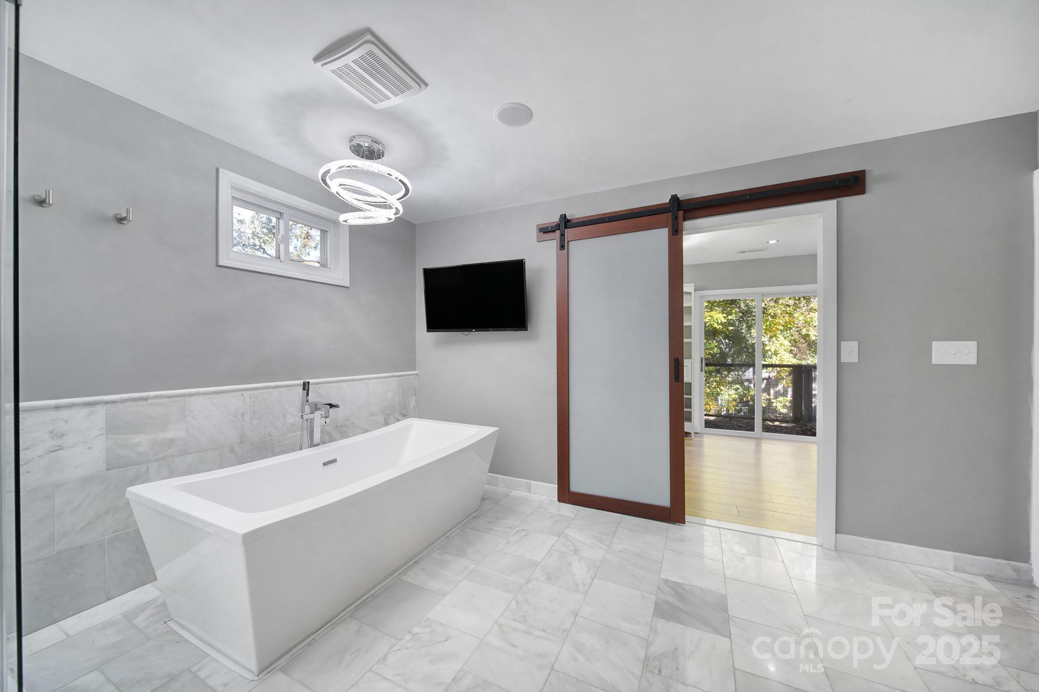7005 Tega Cay Drive Tega Cay, SC 29708 - Photo 30 of 48 a spacious bathroom with a bathtub and a flat screen tv