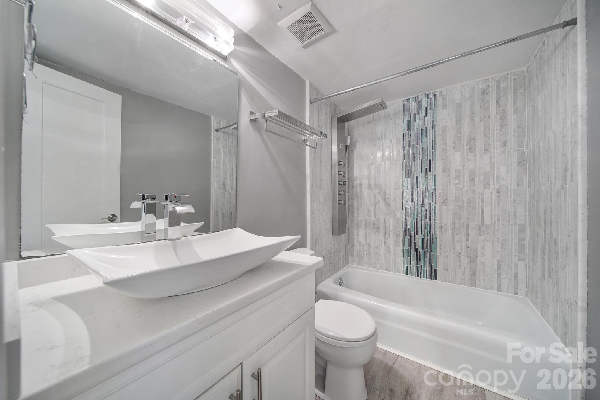 7005 Tega Cay Drive Tega Cay, SC 29708 - Photo 34 of 48 a bathroom with a sink a toilet a mirror a bathtub and shower