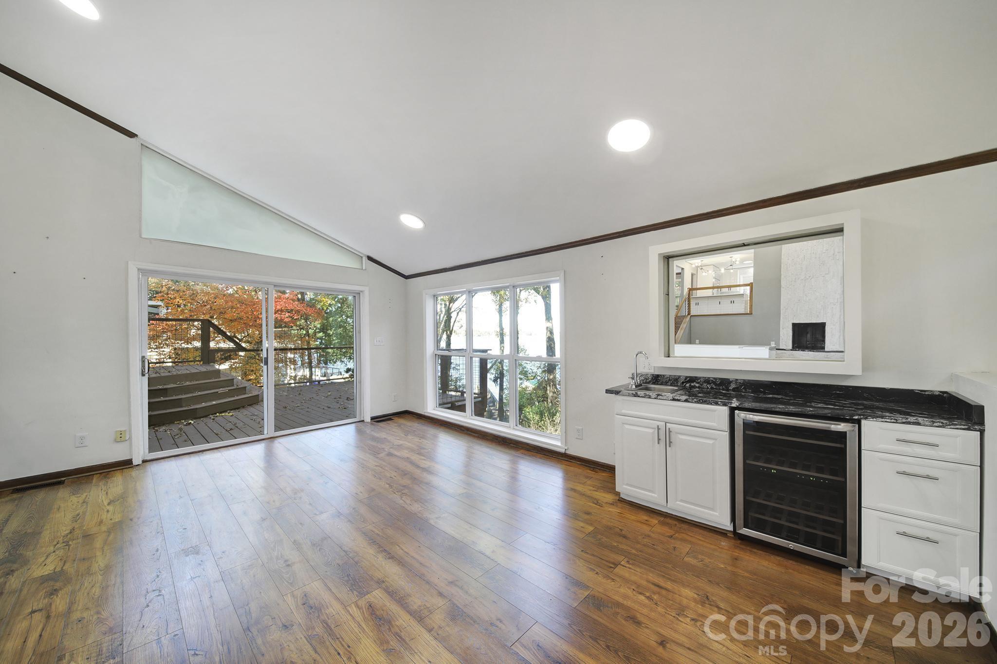 7005 Tega Cay Drive Tega Cay, SC 29708 - Photo 39 of 48 a large kitchen with granite countertop a stove top oven a sink and dishwasher with wooden floor
