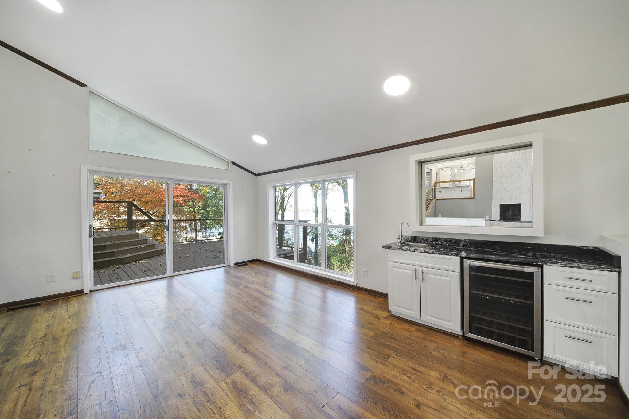 7005 Tega Cay Drive Tega Cay, SC 29708 - Photo 42 of 48 a open kitchen with granite countertop a stove top oven a sink with wooden floors and cabinets