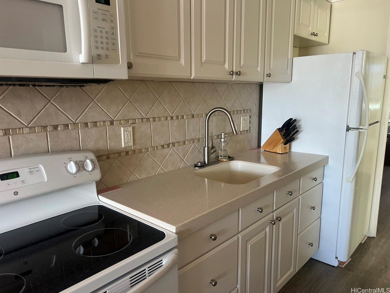 425 Ena Road, Unit B1002 Honolulu, HI 96815 - Photo 9 of 20 a kitchen with stainless steel appliances a sink a stove and a refrigerator with wooden cabinets