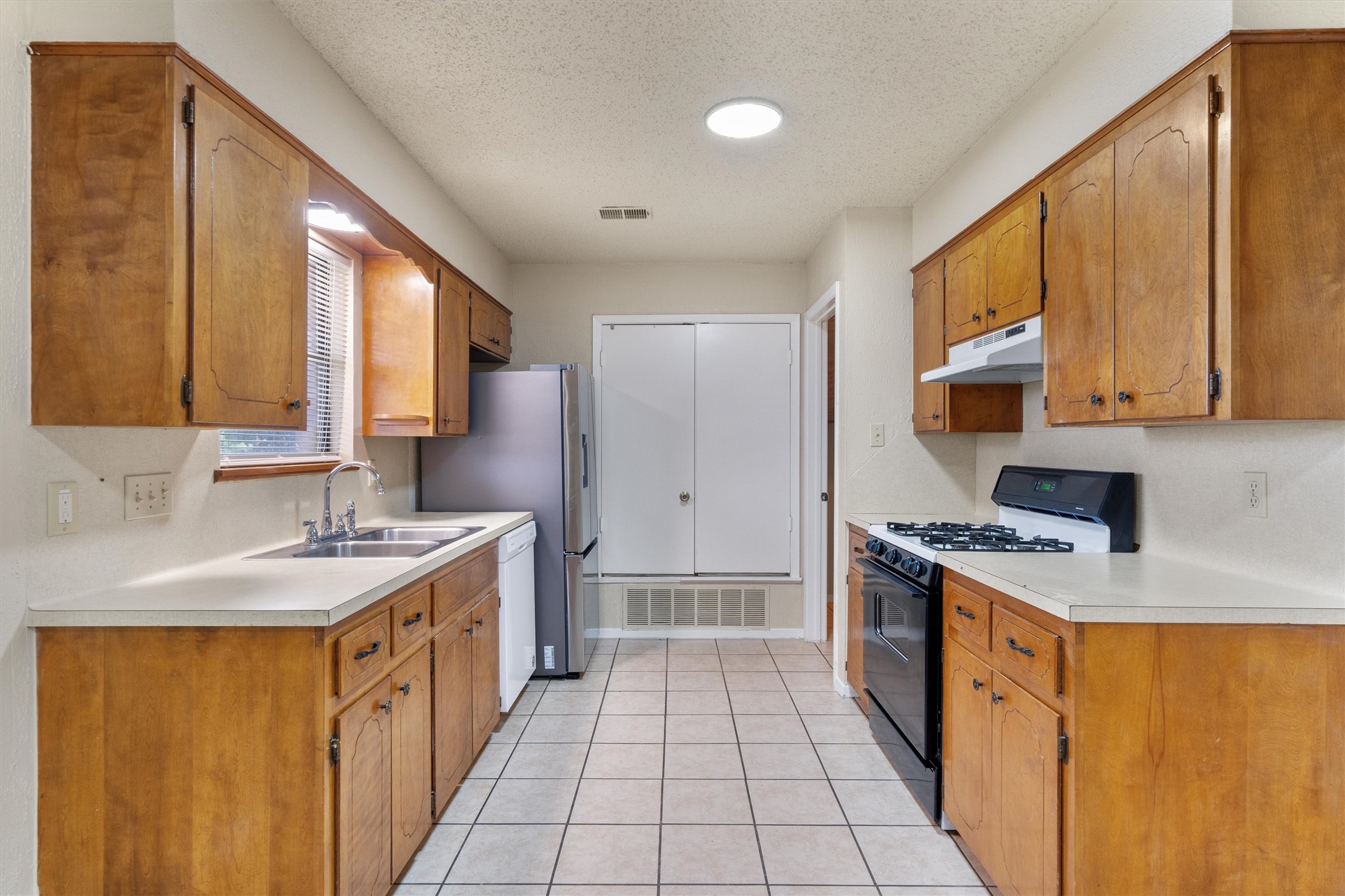 2805 Davis Street, Unit A Taylor, TX 76574 - Photo 5 of 12 a kitchen with stainless steel appliances granite countertop a sink stove and refrigerator