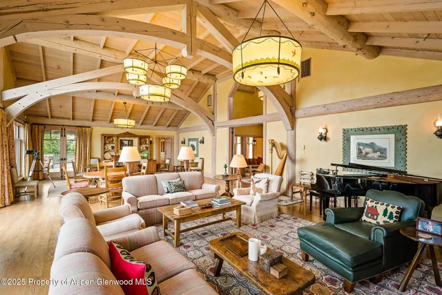 a living room with furniture two large windows and a couch