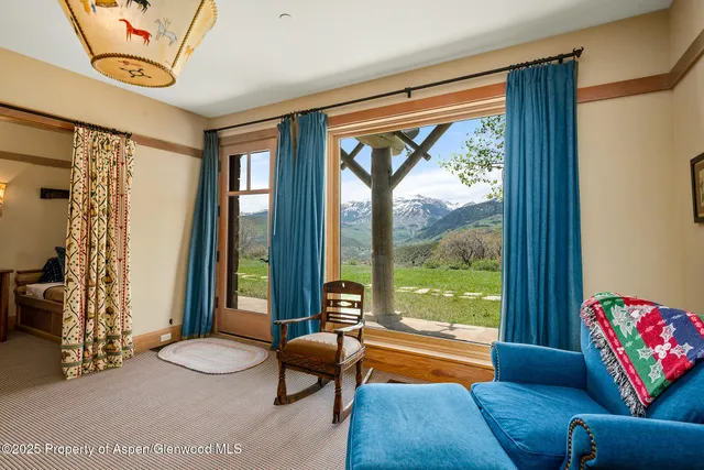 a bedroom with a bed and large windows