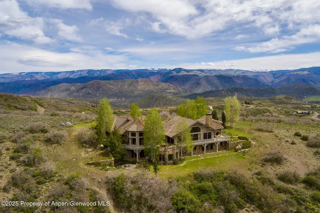 a living room with fireplace furniture and a large window