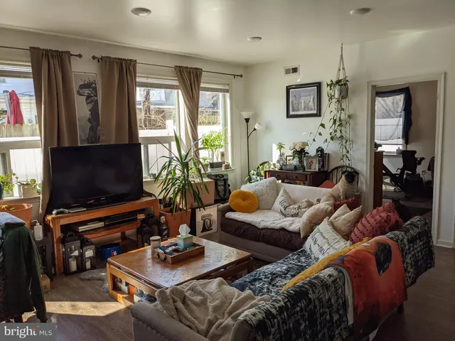 a living room with furniture a flat screen tv and a window