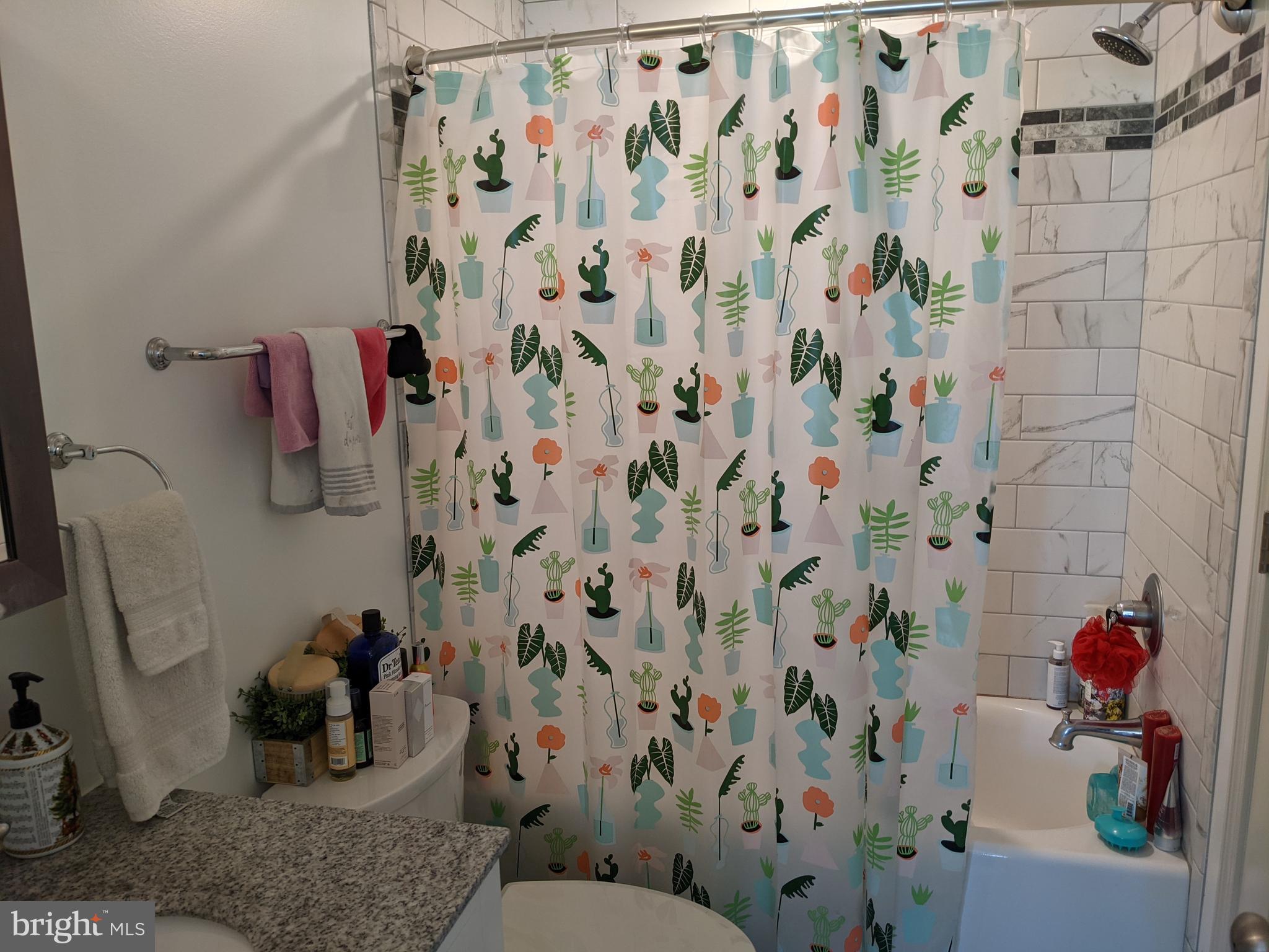4114 Lauriston Street, Unit 105 Philadelphia, PA 19128 - Photo 7 of 8 a bathroom with a shower curtain