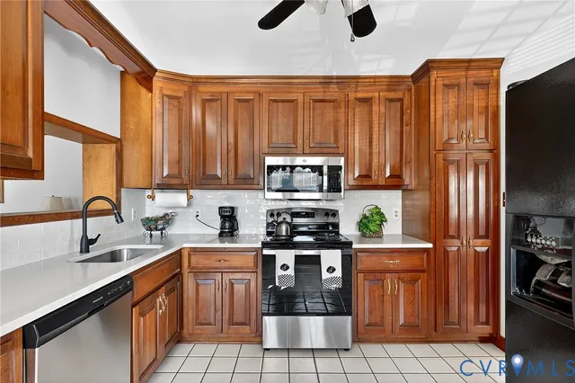 a kitchen with stainless steel appliances a stove a sink a microwave and cabinets