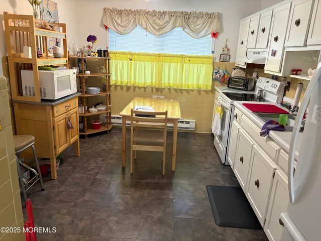 a kitchen with granite countertop a stove a sink and a refrigerator