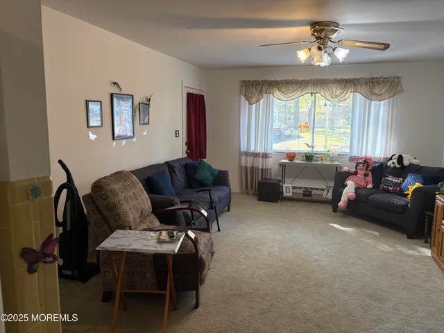 a living room with furniture a chandelier and a window