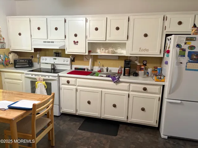 a kitchen with cabinets and white appliances