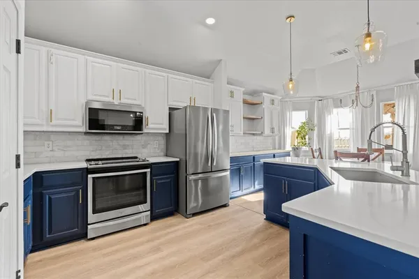 a kitchen with kitchen island granite countertop a stove a sink and a center island