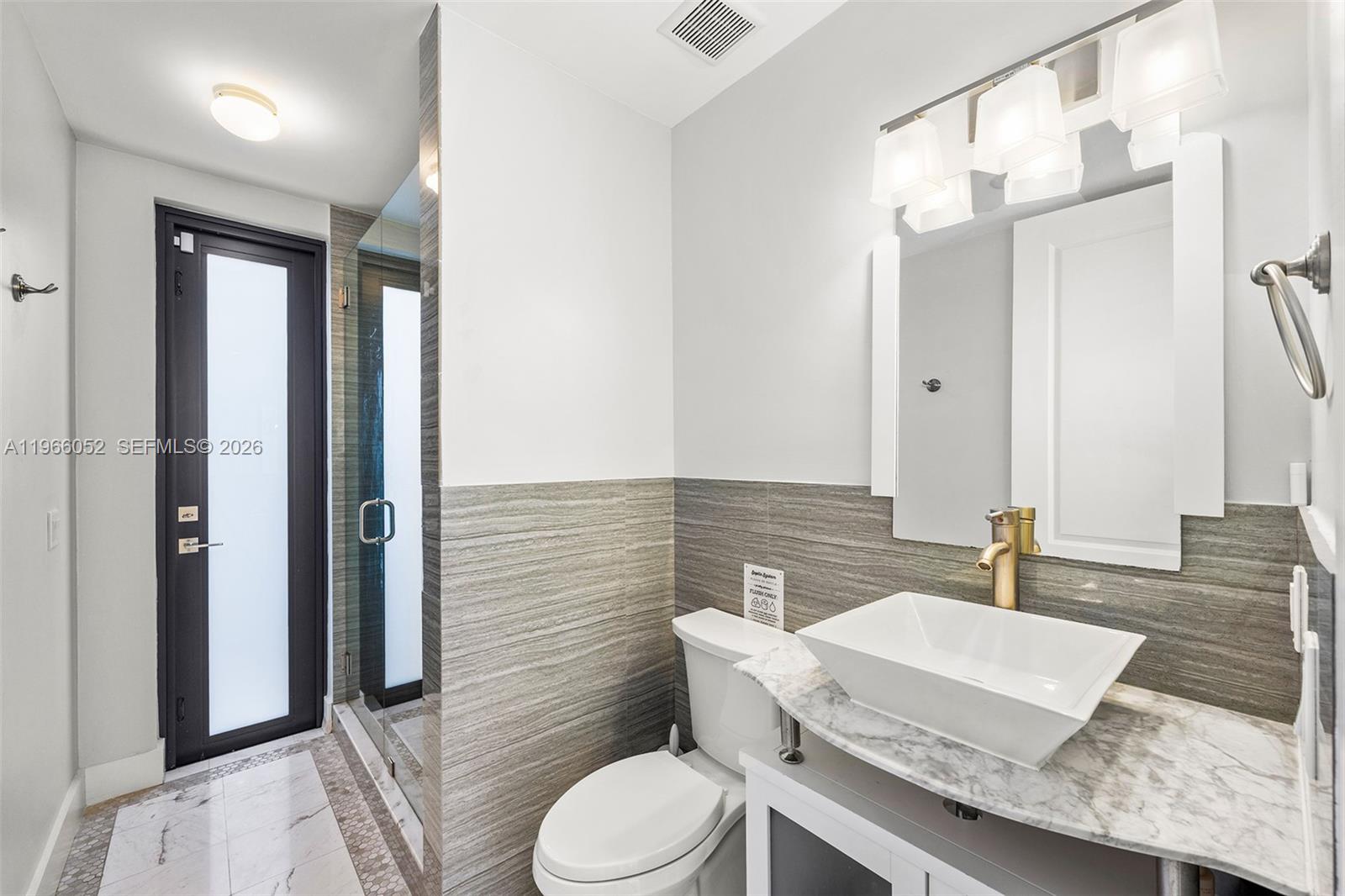 6001 Southwest 28th Street Miami, FL 33155 - Photo 14 of 30 a bathroom with a sink a toilet and mirror