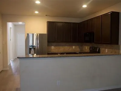 a kitchen with stainless steel appliances granite countertop a refrigerator and a stove