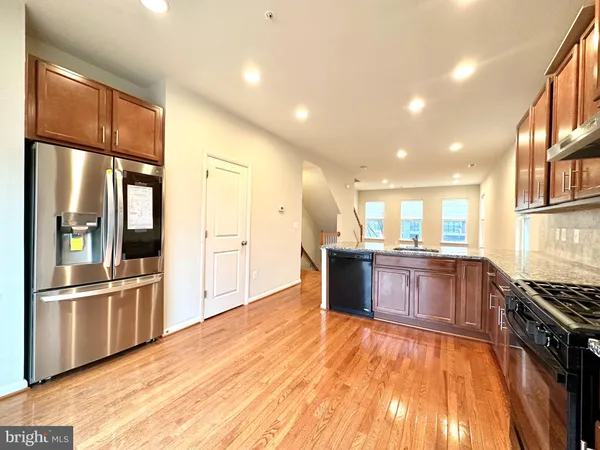 a large kitchen with stainless steel appliances granite countertop a refrigerator and a stove top oven