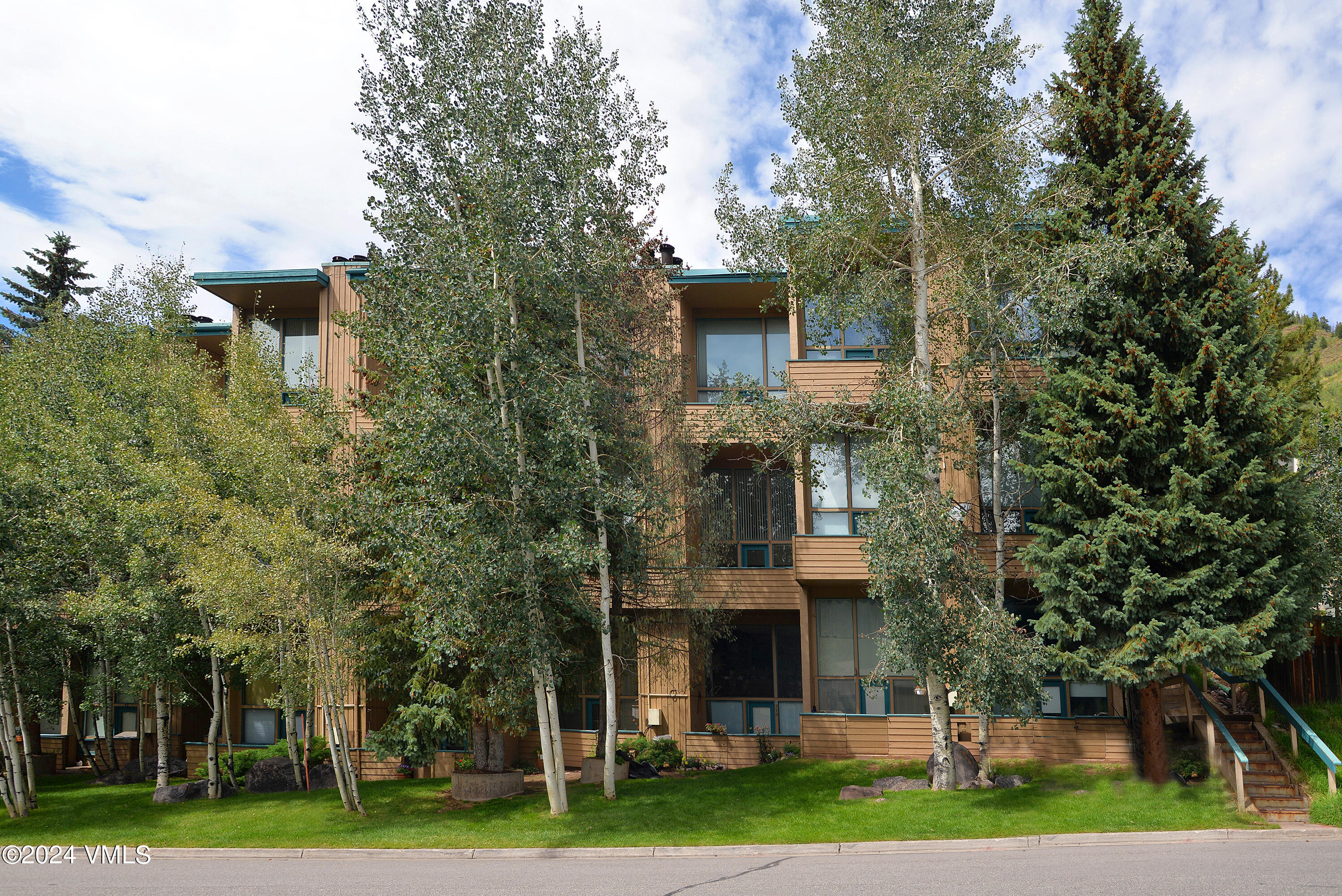 1081 Vail View Drive, Unit B208 Vail, CO 81657 - Photo 20 of 22 a front view of a house with a yard and large trees