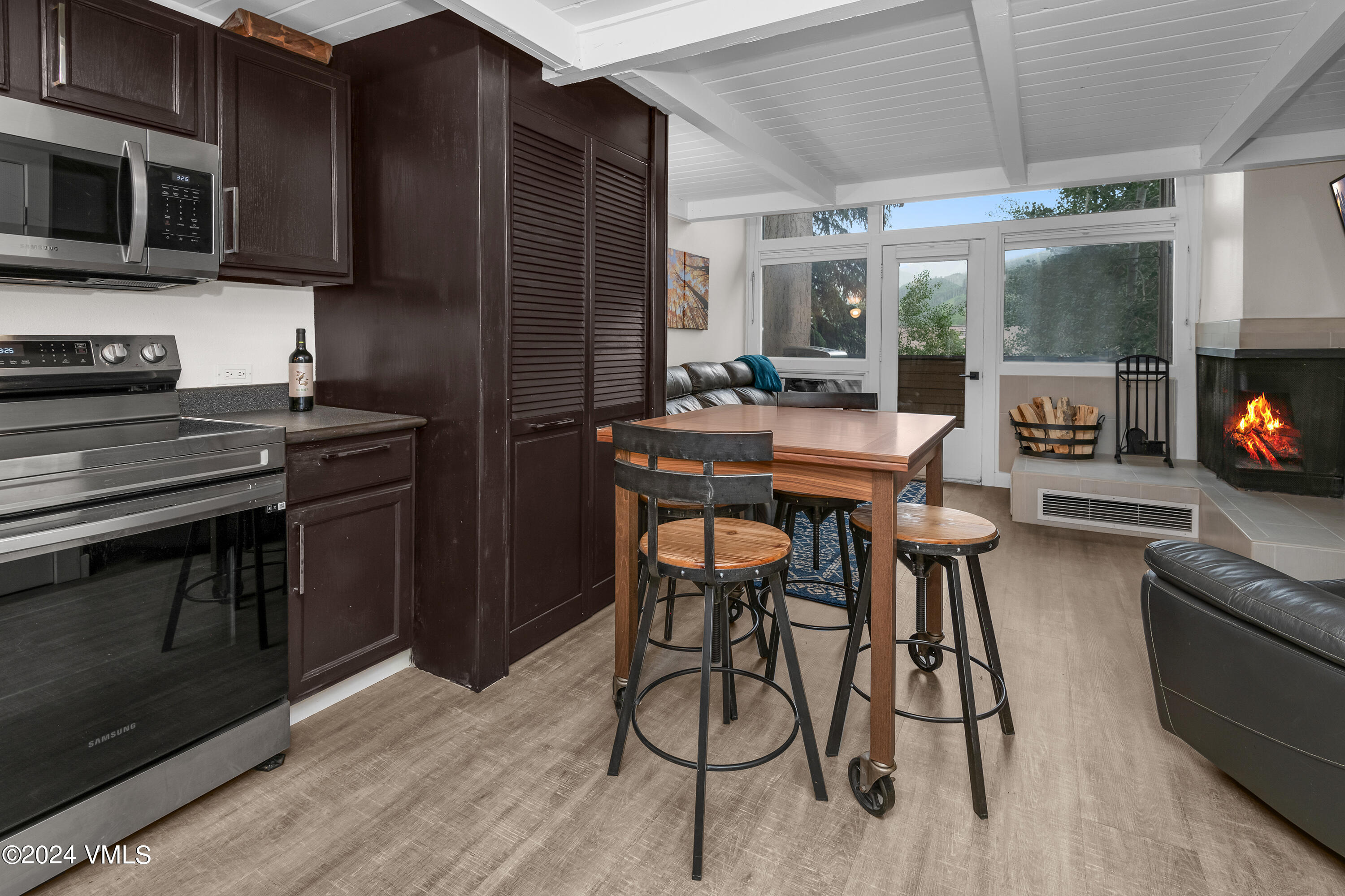 1081 Vail View Drive, Unit B208 Vail, CO 81657 - Photo 4 of 22 a kitchen with stainless steel appliances kitchen island granite countertop a table chairs microwave and sink