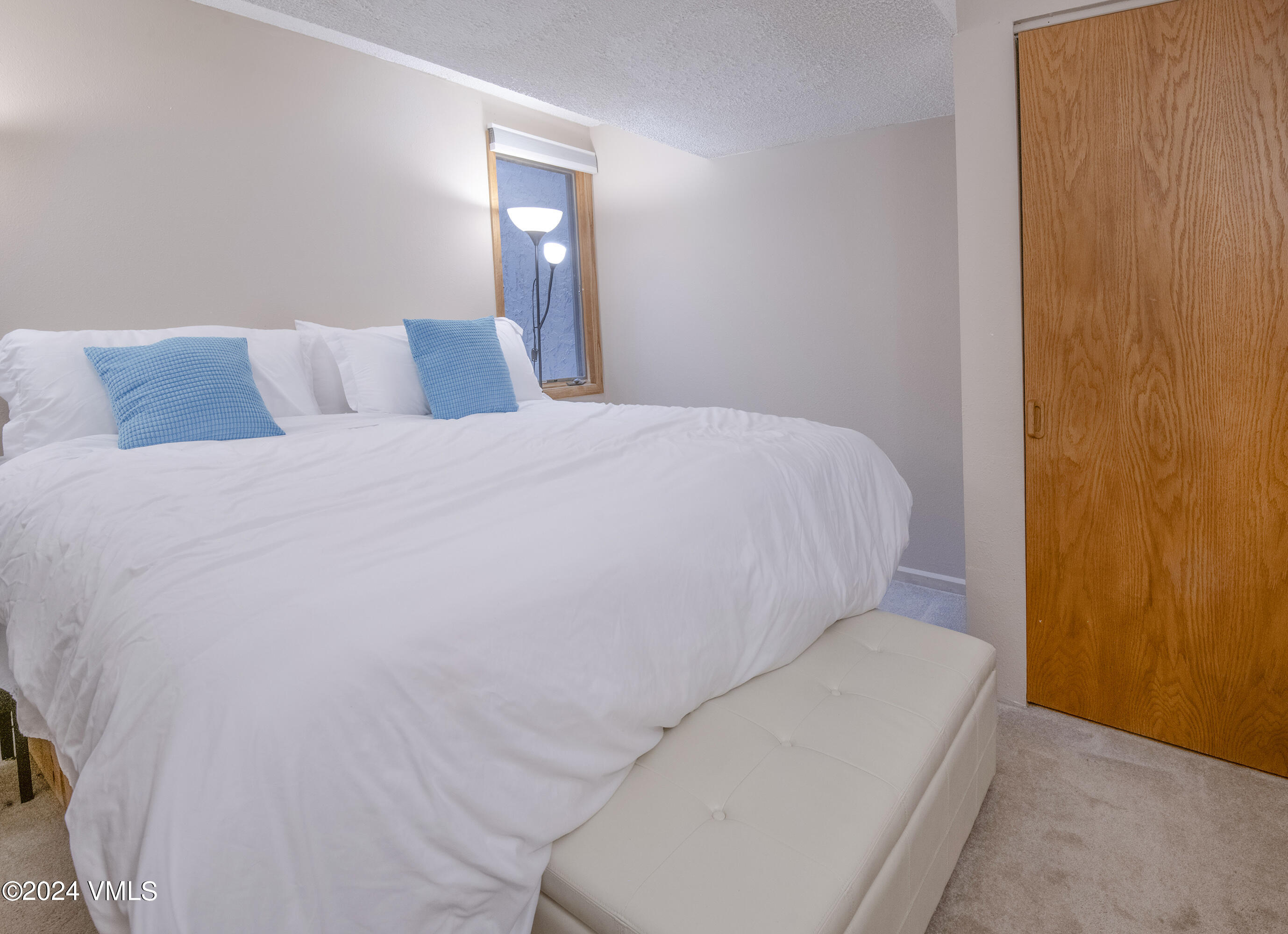 1081 Vail View Drive, Unit B208 Vail, CO 81657 - Photo 9 of 22 a bed sitting in a bedroom with a lamp