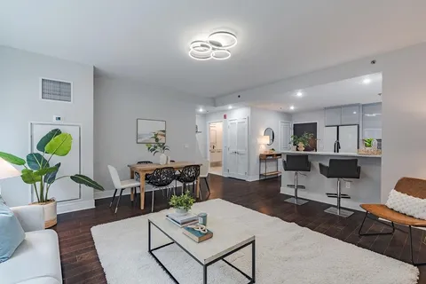 a living room with furniture a dining table and a large window