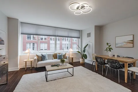 a living room with furniture a dining table and a large window