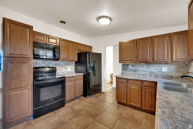 360 400 North Centerville, UT 84014 - Photo 16 of 30 Kitchen with wood-finish cabinetry, black appliances, textured tile backsplash, and stone-finish countertops