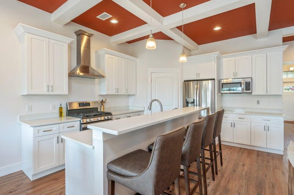 508 Harborview Circle Niceville, FL 32578 - Photo 14 of 60 a kitchen with stainless steel appliances granite countertop a stove a refrigerator a sink a dining table and chairs with wooden floor